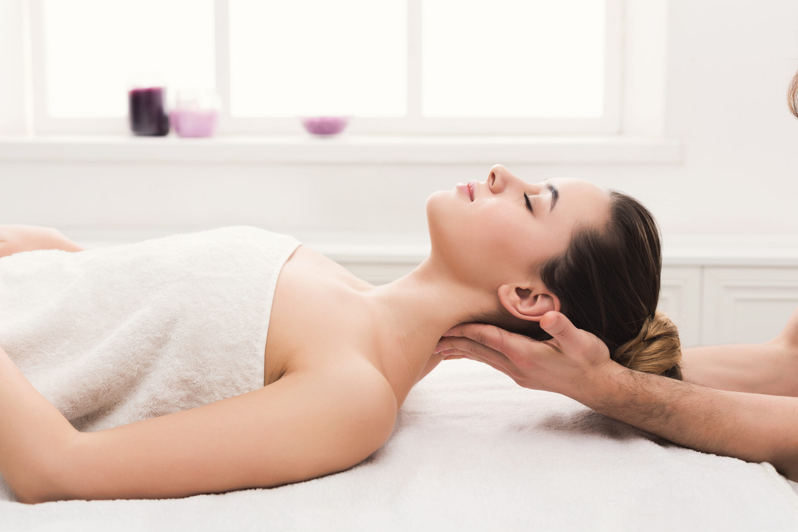 Classical neck and back massage, closeup. Woman enjoying spa treatment at salon. Wellness, beauty and health care concept, side view
