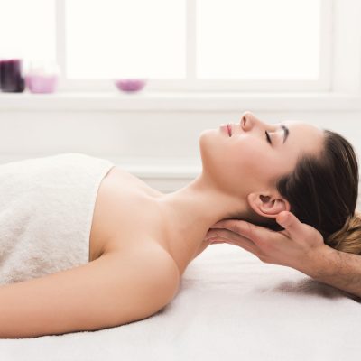 Classical neck and back massage, closeup. Woman enjoying spa treatment at salon. Wellness, beauty and health care concept, side view